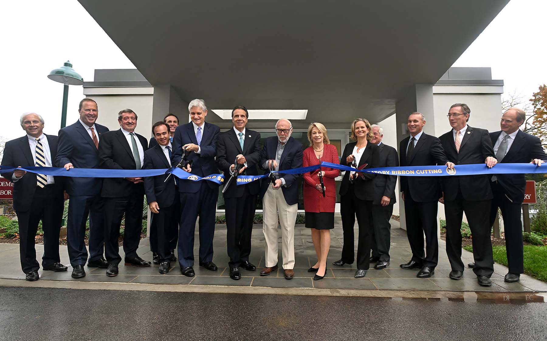 photo of Andrew Cuomo, Bruce Stillman and others cutting the ribbon in front of Demerec building