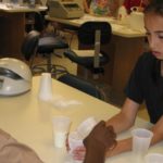 Photo of two middle school age students in a DNALC lab testing milk samples for lactase