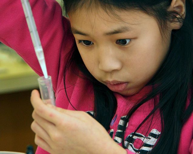 photo of a young student pipetting