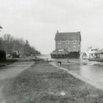 image of the Cold Spring Harbor Village Firehouse moving across the harbor circa 1930s