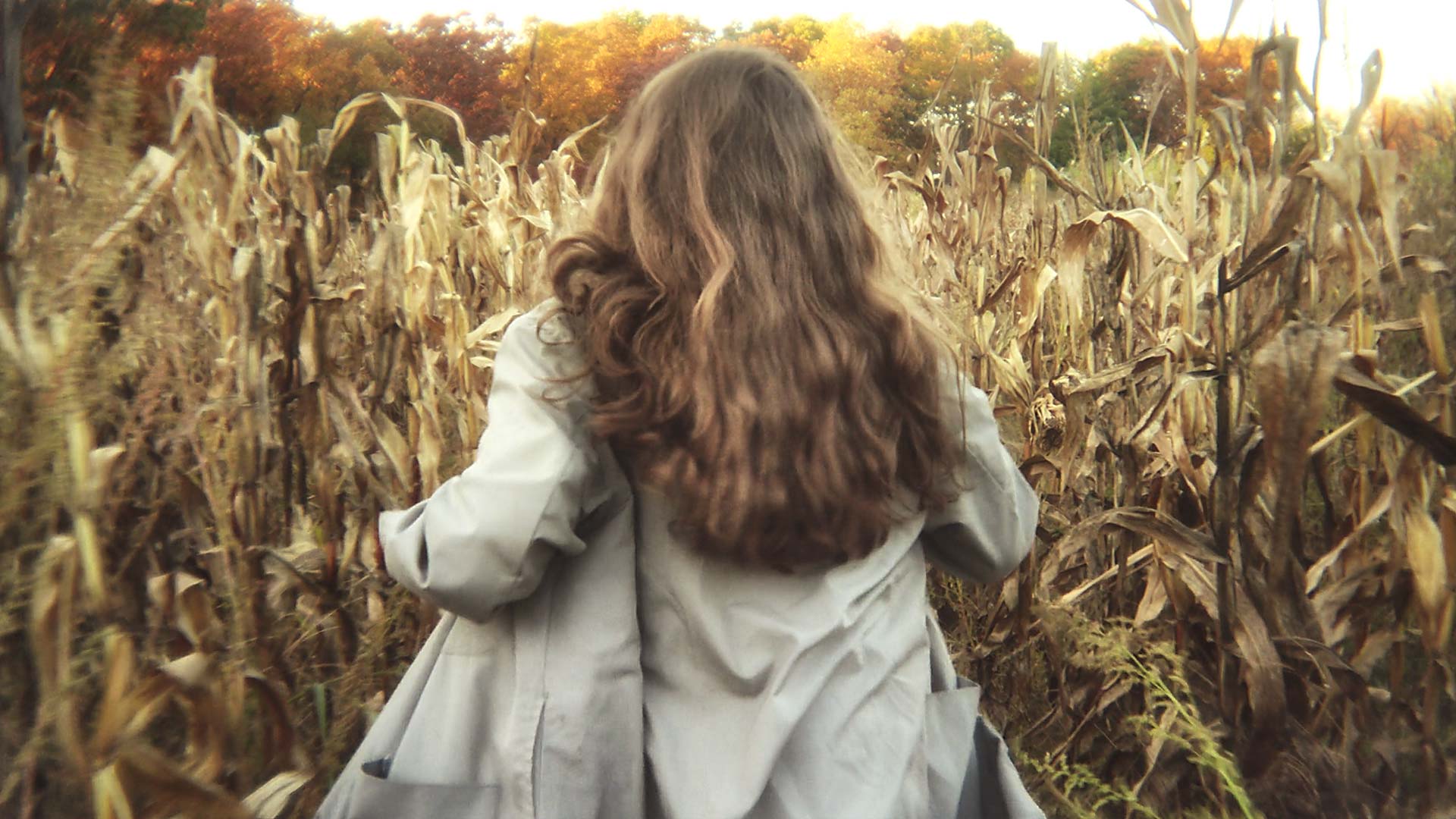 image of a woman running through a corn field