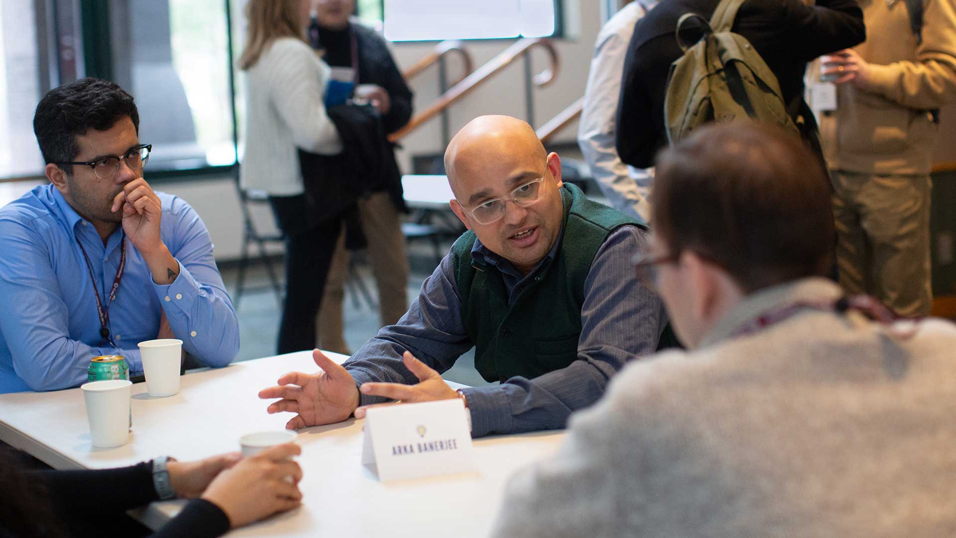 Image of Arkarup Banerjee speaking with graduate students at the 2025 CSHL Innovators Symposium