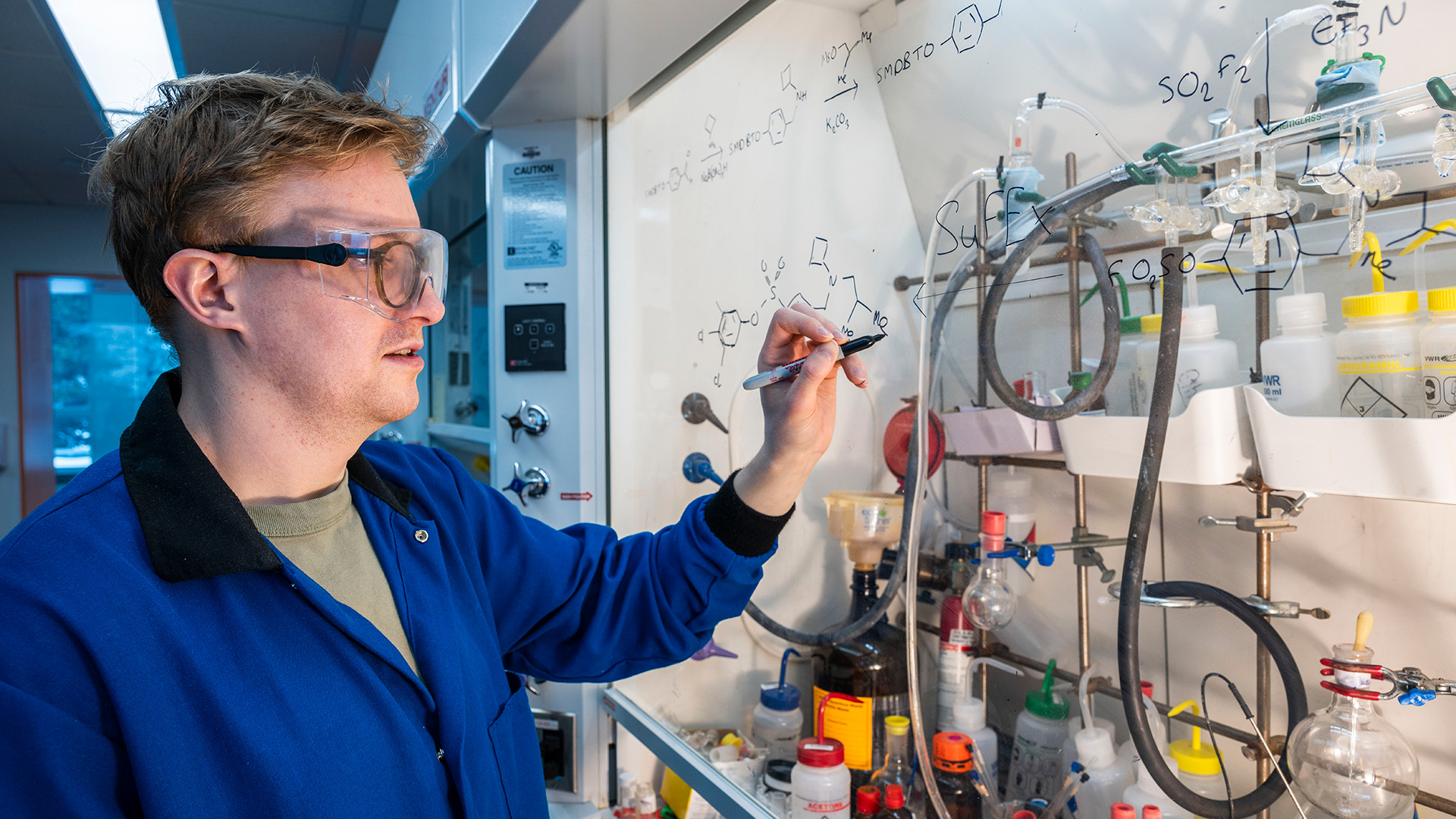 Image of Elliot Smith sketching a formula in the Moses lab