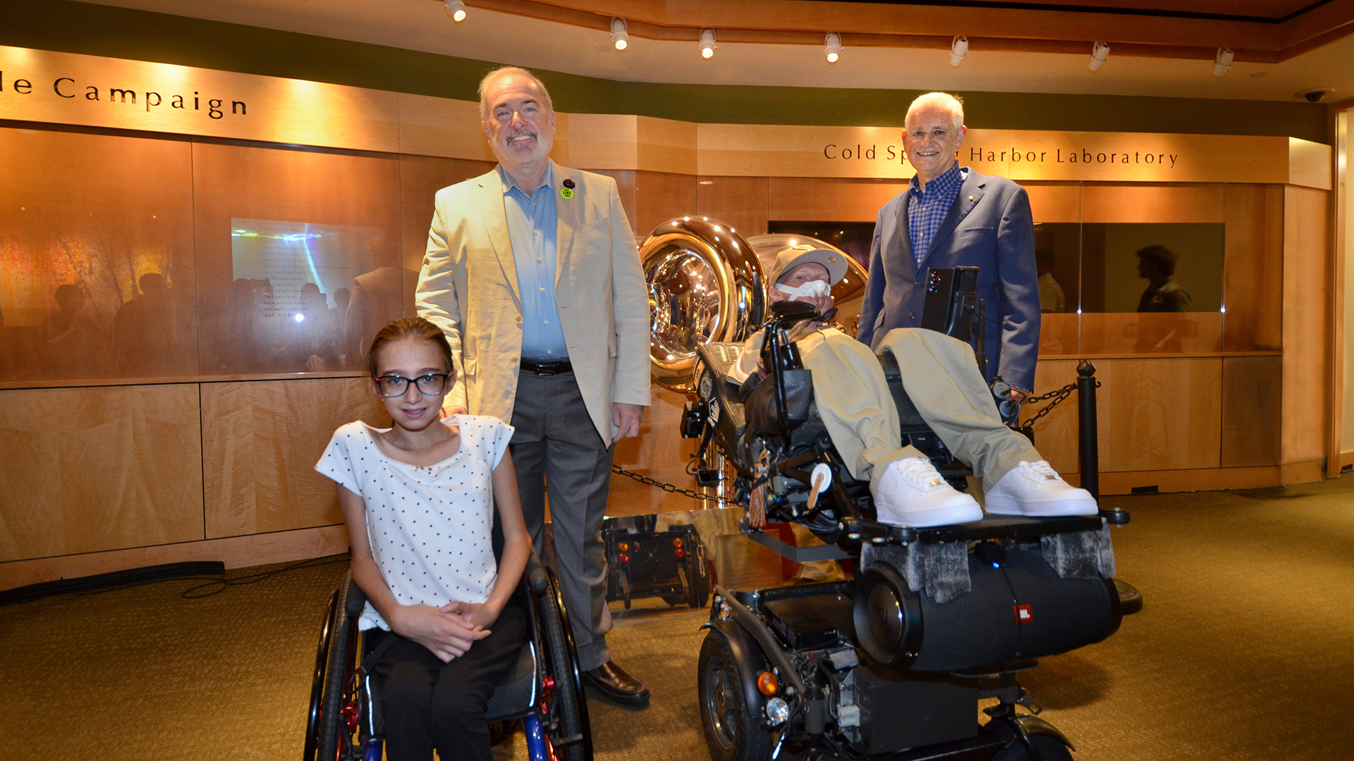 Emma Larson, Adrian Krainer, Phil L. Herold, Bruce Stillman, posing indoors at Cold Spring Harbor Laboratory exhibit.